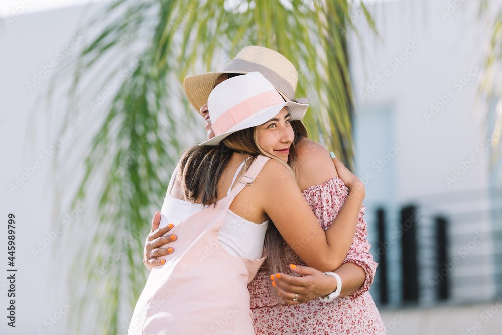 Mexican sisters hugging and smiling on summer vacation
