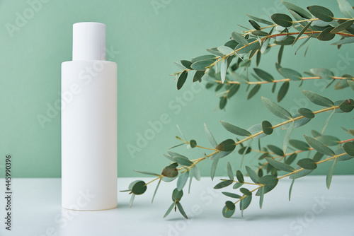 Beauty cosmetic product in white bottle on green background. Natural organic cosmetics