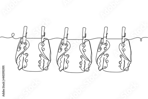 Continuous one line of reusable cloth baby diapers drying on a clothesline in silhouette on a white background. Linear stylized.Minimalist.