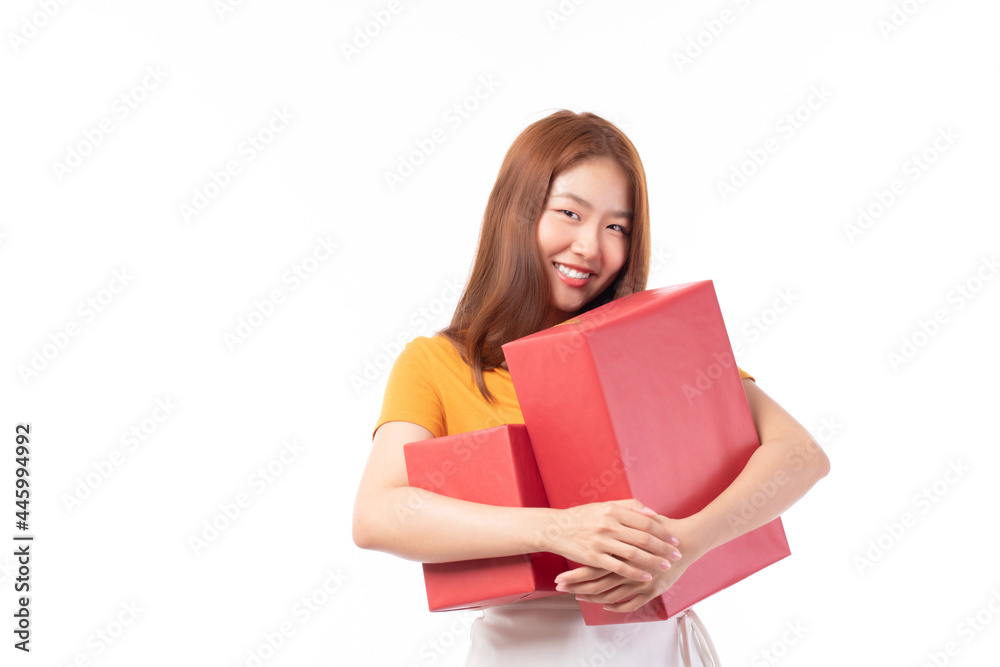 Attractive Asian woman holding gift box in christmas, new year, valentine day, birthday celebration concept. Portrait of smiling happy pretty girl hold gift box isolated on white with copy space.