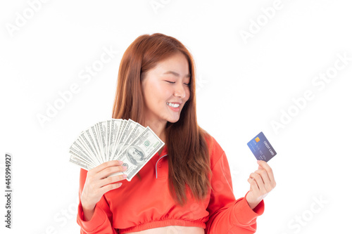 portrait smiling Asian woman in red T-shirt holding money with credit card isolated on white background.