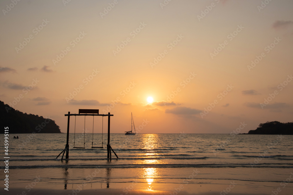 Summer vacation concept. Beautiful silhouette empty wood swing sunset or sunrise on the beach in Phuket, Thailand.