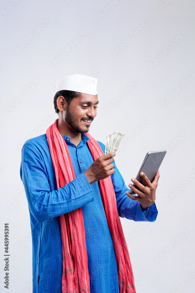 Young indian farmer using smartphone and showing money on white background. Young indian farmer using smartphone and showing money on white background.