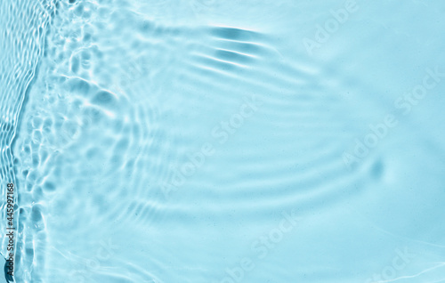 Summer banner background. Blue liquid colored clear water surface texture with splashes bubbles. Trendy blue nature background. Blurred or defocused transparent clear water.
