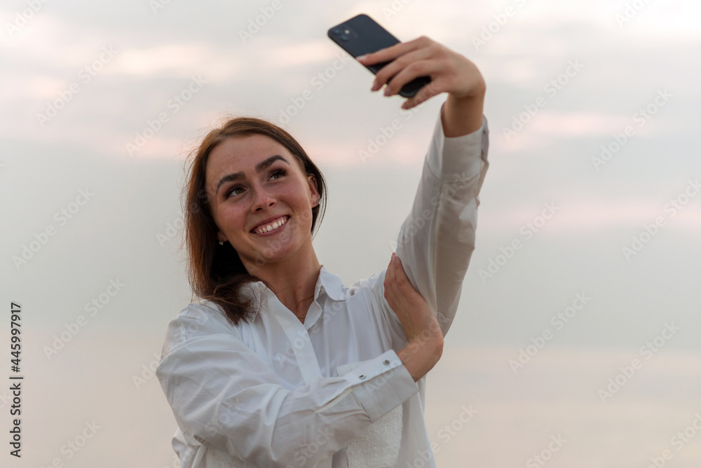 Selfie photo of young model woman on holidays.female happy smiling using mobile phone taking selfie on beach near sea.