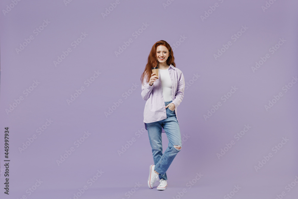Full size body length young redhead curly woman 20 wear white T-shirt violet jacket hold takeaway delivery craft paper brown cup coffee isolated on pastel purple color wall background studio portrait Full size body length young redhead curly woman 20 wear white T-shirt violet jacket hold takeaway delivery craft paper brown cup coffee isolated on pastel purple color wall background studio portrait