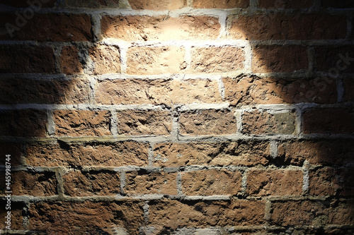 Brick wall covered with a lamp, light on a brick surface