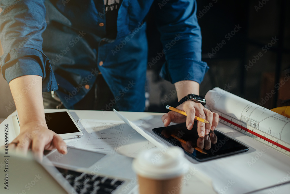 Concept architects or engineer holding pen and tablet pointing equipment architects on the desk with a blueprint in the office. Concept architects or engineer holding pen and tablet pointing equipment architects on the desk with a blueprint in the office.