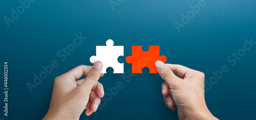 Businessman hands connecting puzzle pieces representing the merging of two companies or joint venture, partnership, Mergers and acquisition concept photo