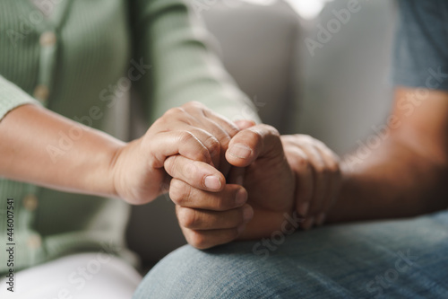 Female friend or family sitting and hold hands during cheer up to mental depress man, Psychologist provides mental aid to patient. PTSD Mental health concept.