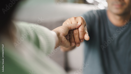 Female friend or family holding hands during cheer up to mental depress man, Psychologist provides mental aid to patient. PTSD Mental health concept..