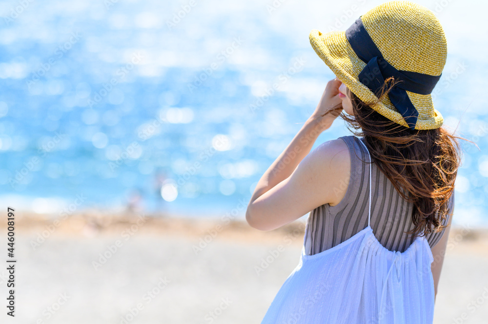 Fototapeta premium 浜辺で遠くを見つめる女性