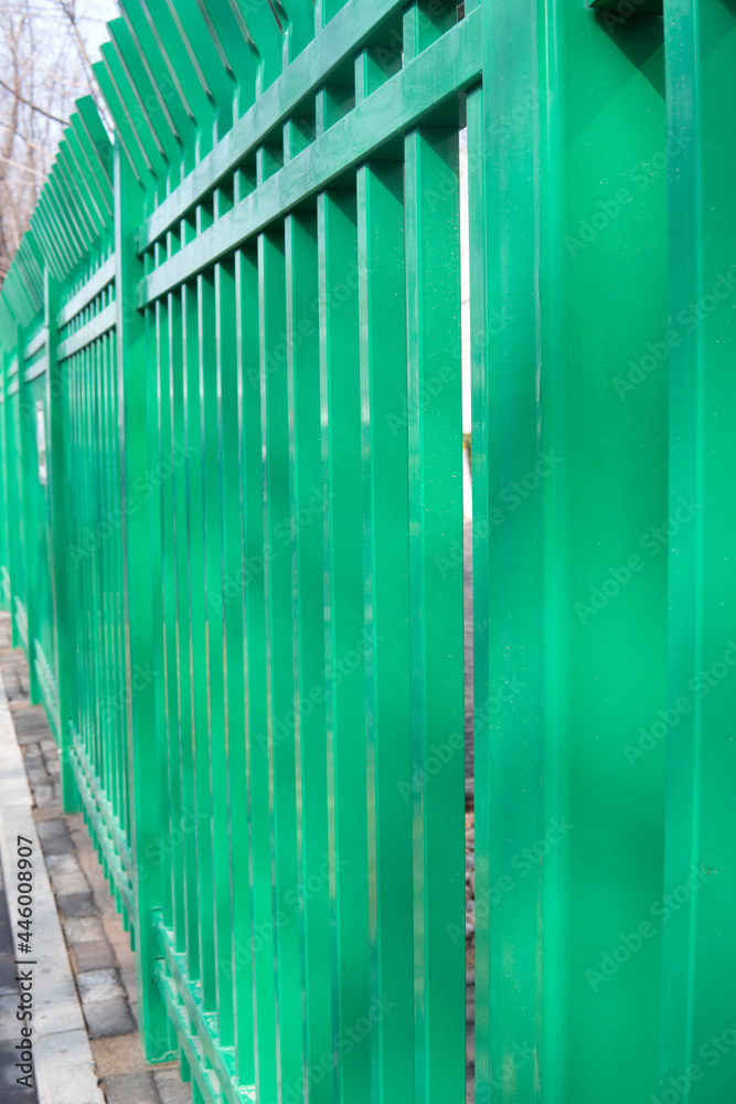 The green painted fence stretches far