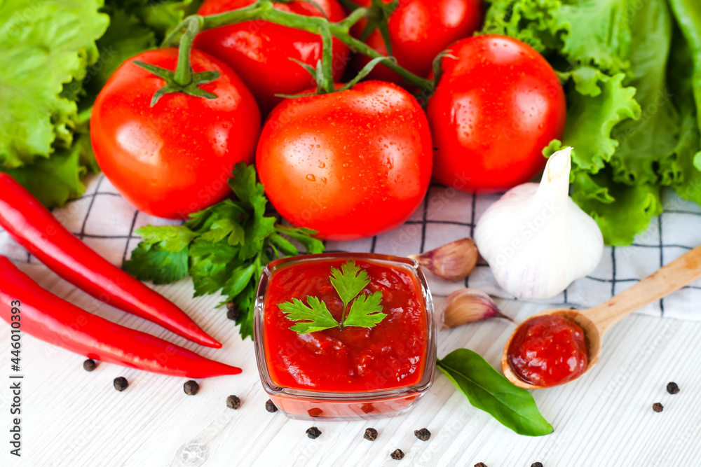 Ketchup, ripe tomatoes and spices on the table. The concept of cooking sauce or ketchup. Close-up. Ketchup, ripe tomatoes and spices on the table. The concept of cooking sauce or ketchup. Close-up.