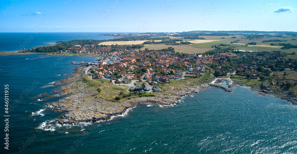 Die dänische Stadt Svaneke auf der Ostsee-Insel Bornholm vor der Granitküste von oben