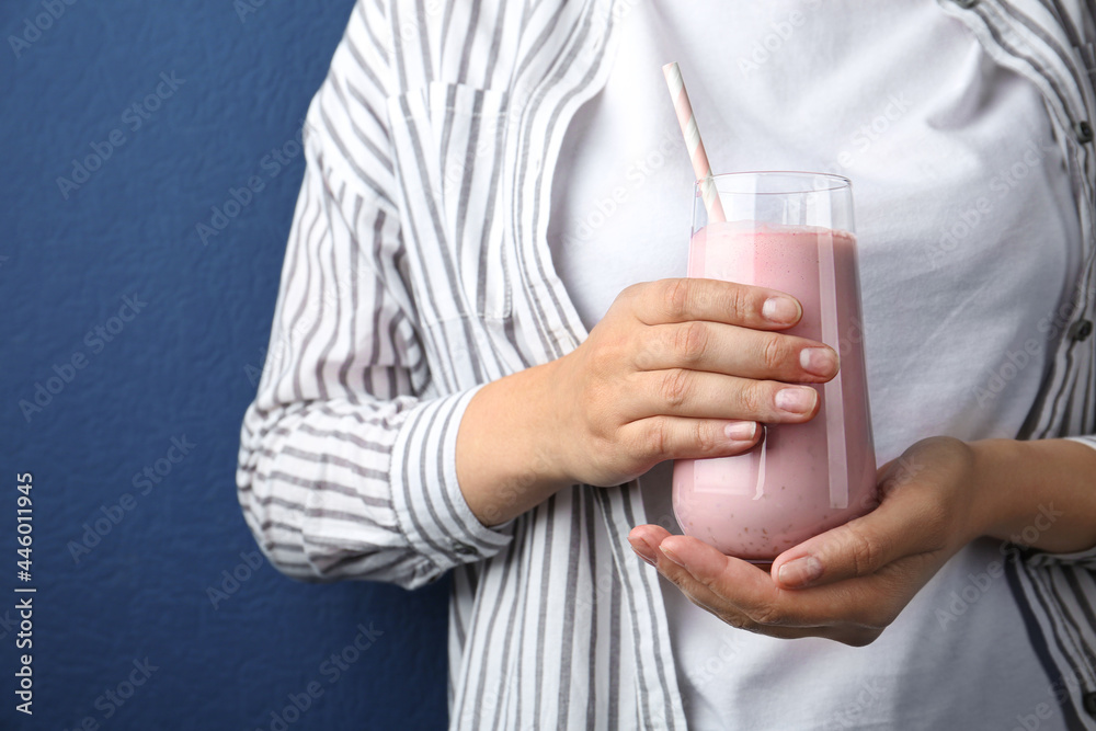 Woman with glass of tasty smoothie on blue background, closeup Woman with glass of tasty smoothie on blue background, closeup