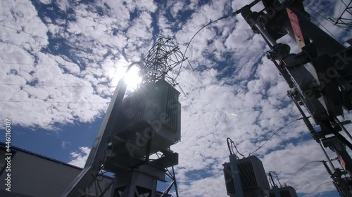 Power transformers and large conservator on swirchyard of electricity production substation under sky with clouds photo