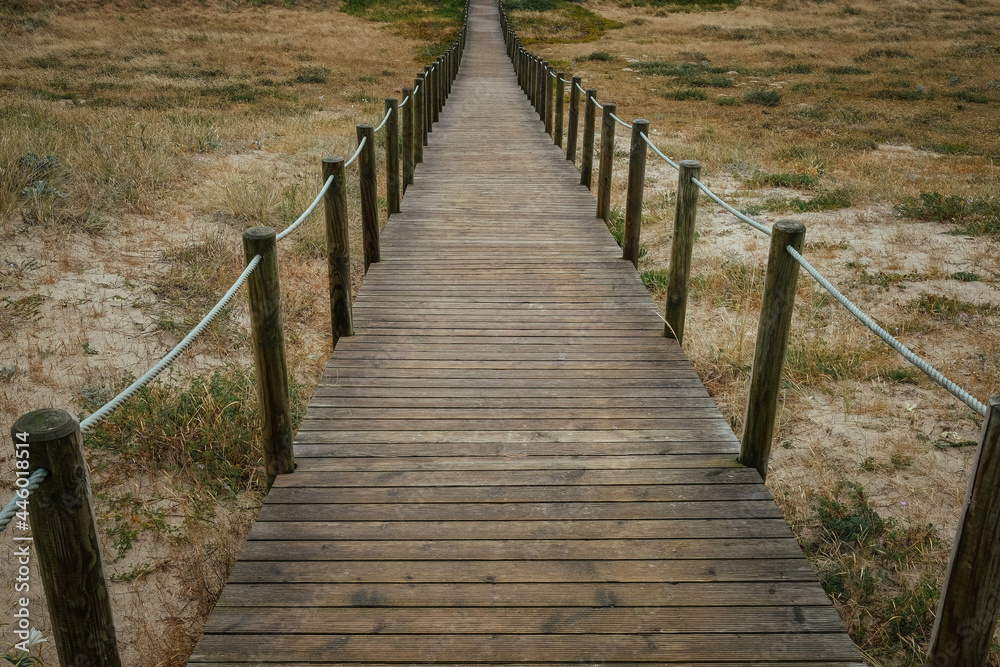 High angle shot of a pathway with roped poles in a field