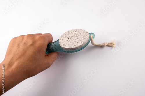 Foot scrub and seam in a woman's hands. White background