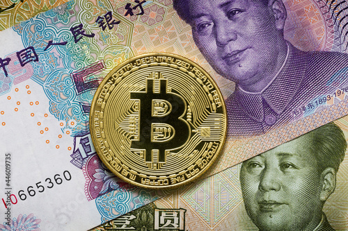 Golden metal bitcoin on a Chineze money. China imposed restrictions on the circulation and mining of bitcoin. photo