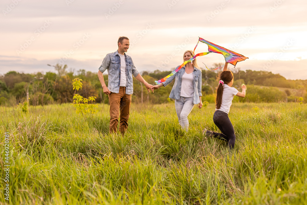 Fototapeta premium Happy family: mother father and child daughter on nature on sunset