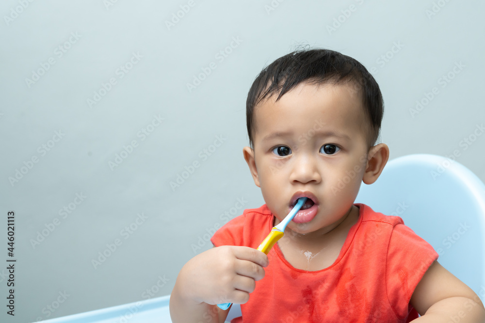 Cute smiling little Asian 1.3 years old toddler boy child holding toothbrush and brushing teeth, Tooth care for children concept Cute smiling little Asian 1.3 years old toddler boy child holding toothbrush and brushing teeth, Tooth care for children concept