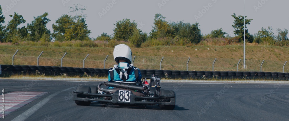 Back view of teenager professional racer driving his go kart on a race track - obrazy, fototapety, plakaty 