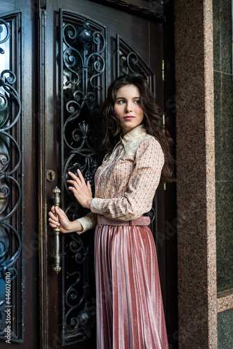 portrait of young lady wear a fashion cloth posing near old texture doors