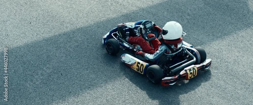 Teenager professional karting racer closing visor and starting his kart on a racetrack. Shot with 2x anamorphic lens photo