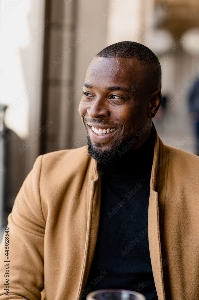 Portrait of black man smiling looking away.