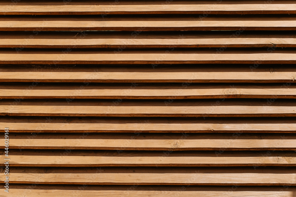 Wooden fence made of horizontal thin boards. Textured brown fence background, wood panels pattern, outdoors Wooden fence made of horizontal thin boards. Textured brown fence background, wood panels pattern, outdoors