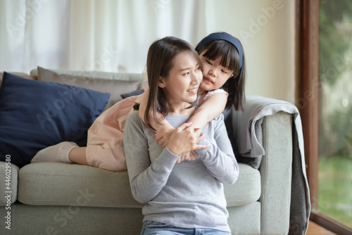 Asian mother make love with warm hug her cute daughter at home