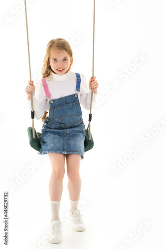 Beautiful teen school girl swinging on a swing. Concept summer vacation.