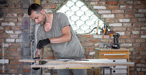Photos Carpenter using f clamp to set up wood in wood working.