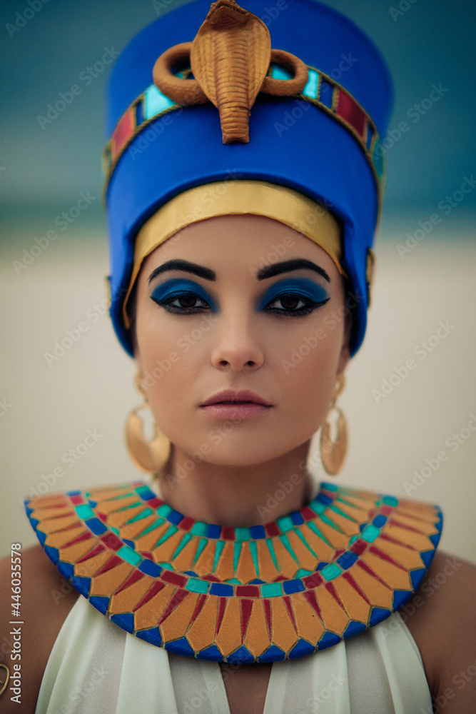 Portrait of woman in image of egyptian queen Nefertiti in desert. - obrazy, fototapety, plakaty 