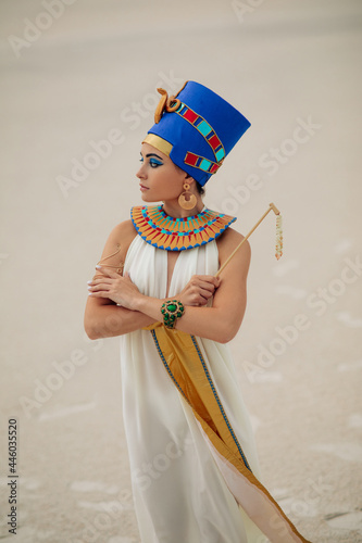 Konstfotografi Woman in image of egyptian queen Nefertiti stands in desert with whip
