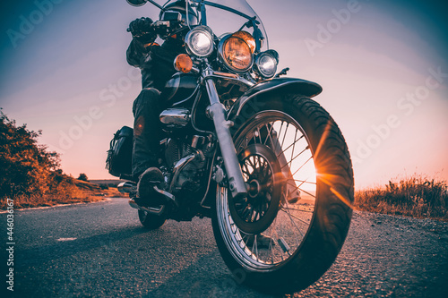 Driver riding motorcycle on an empty road photo