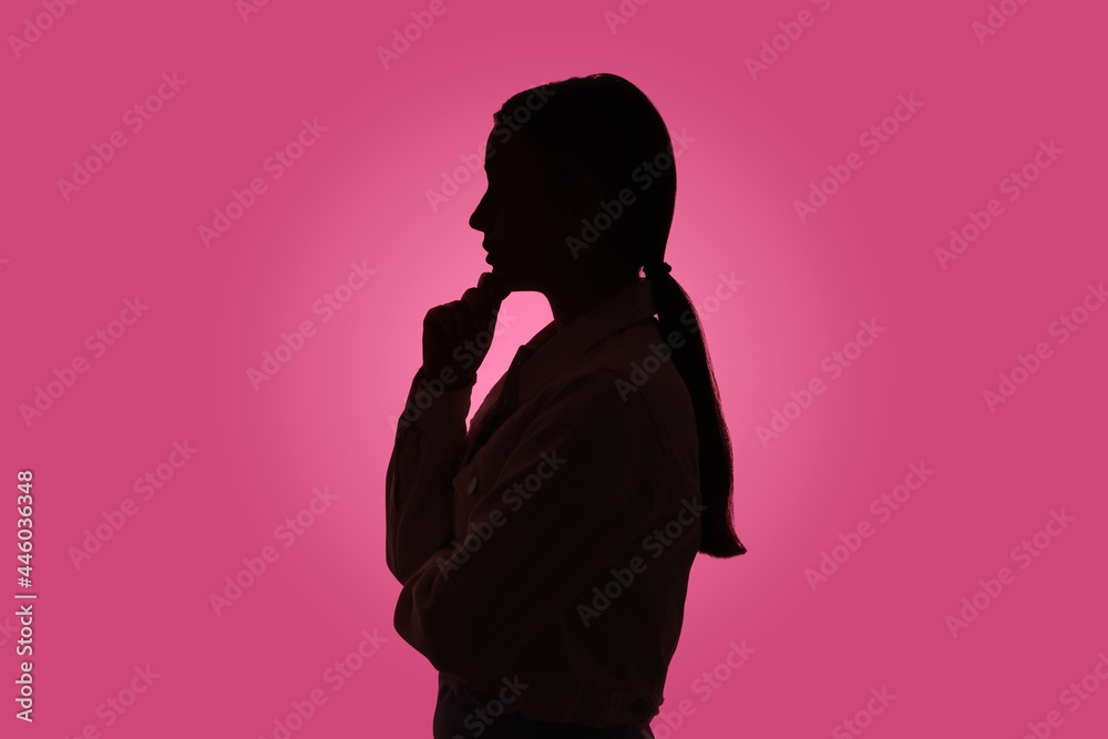 Silhouette of anonymous woman on pink background