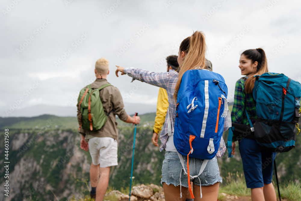 Group of happy friends with backpacks hiking together - obrazy, fototapety, plakaty 