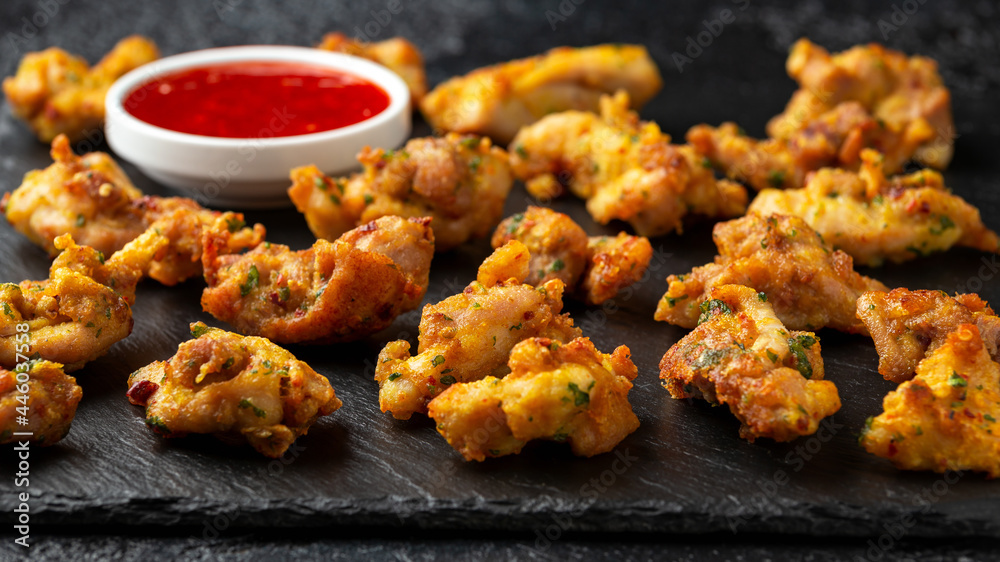 Chicken Pakora dish with sweet chilli sauce on rustic stone board Chicken Pakora dish with sweet chilli sauce on rustic stone board