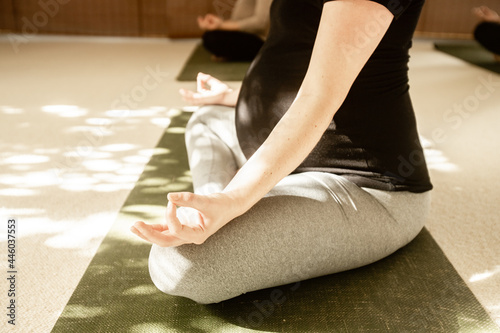 young pregnant woman practicing maternity yoga photo