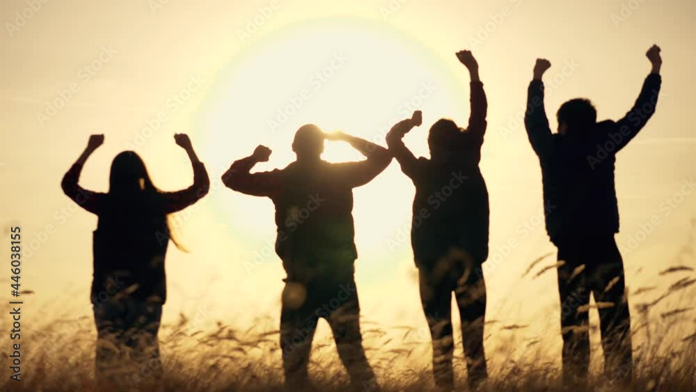 Silhouette of hands up. team of tourists shakes up, rejoicing, raising their hands in greeting. silhouette of team, families at sunset rejoicing, jumping up down. Family team having fun at sunset Silhouette of hands up. team of tourists shakes up, rejoicing, raising their hands in greeting. silhouette of team, families at sunset rejoicing, jumping up down. Family team having fun at sunset