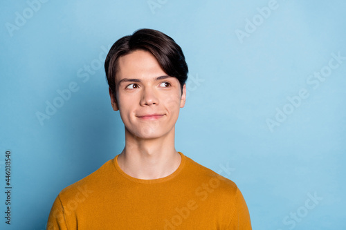 Photo of funny brunet young man look empty space wear brown sweater isolated on blue color background