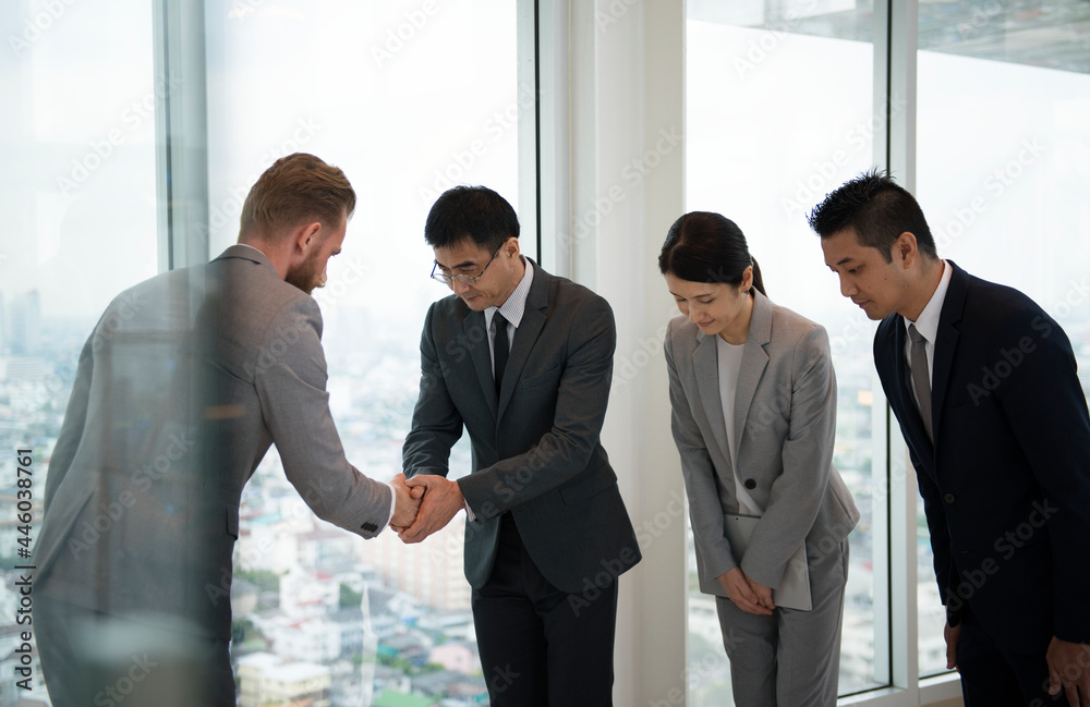 Japanese businessman people having a handshake with a colleague Japanese businessman people having a handshake with a colleague