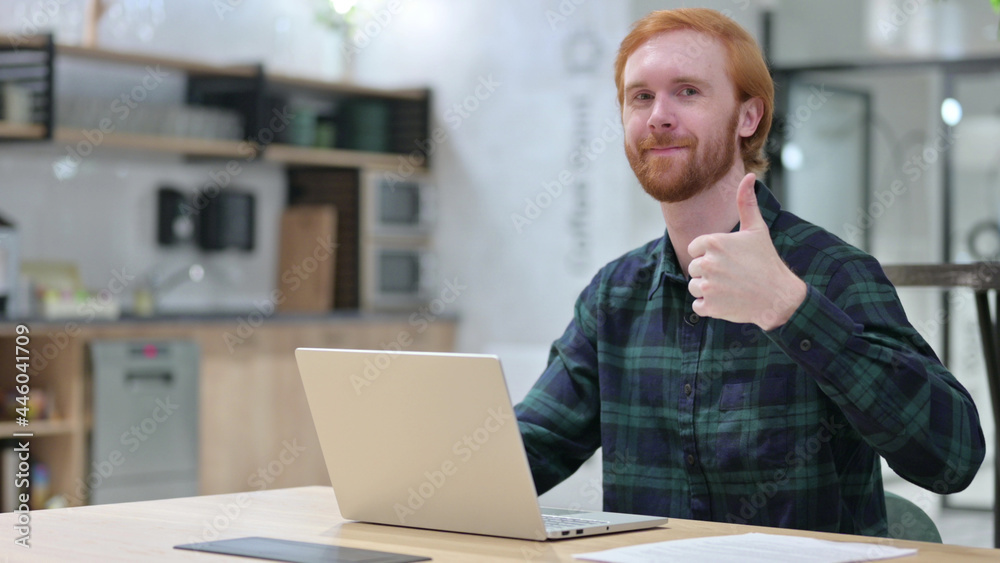 Positive Redhead Man with Laptop showing Thumbs Up Positive Redhead Man with Laptop showing Thumbs Up