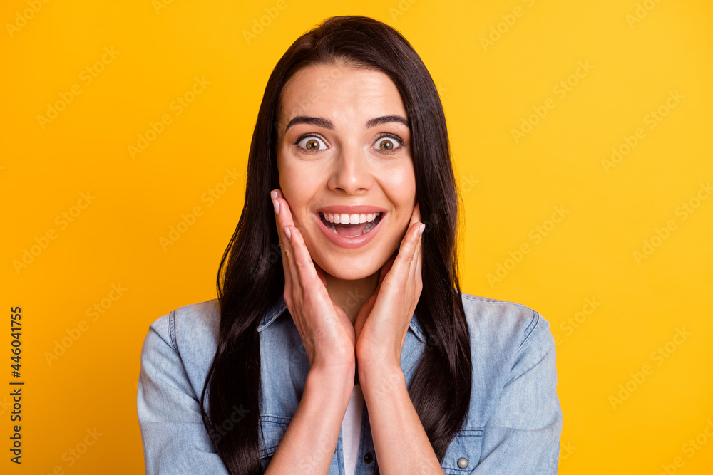 Photo of impressed charming lady arms on cheeks open mouth cant believe isolated on yellow color background Photo of impressed charming lady arms on cheeks open mouth cant believe isolated on yellow color background