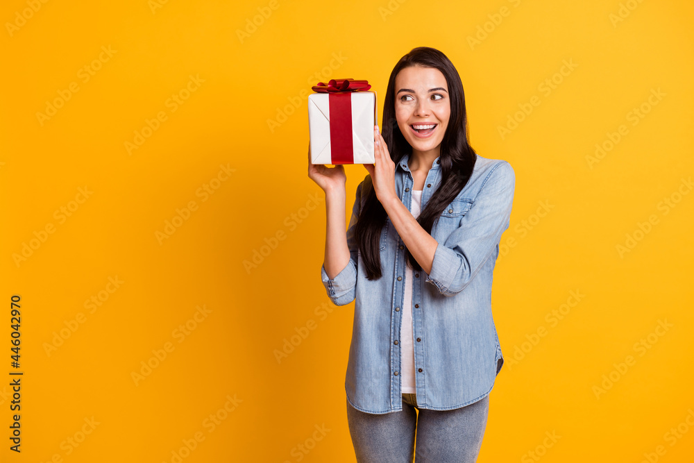 Photo of nice optimistic brunette lady hold present wear blue shirt isolated on bright yellow color background