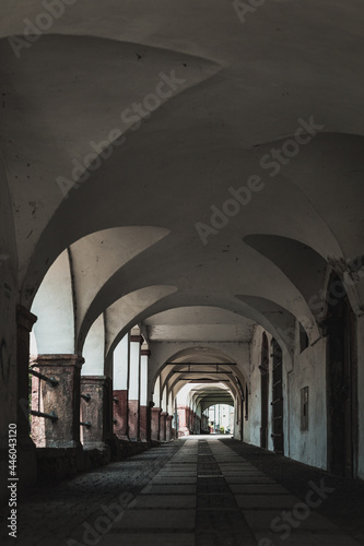 empty arcade passageway in small town, architecture with arches, vertical format