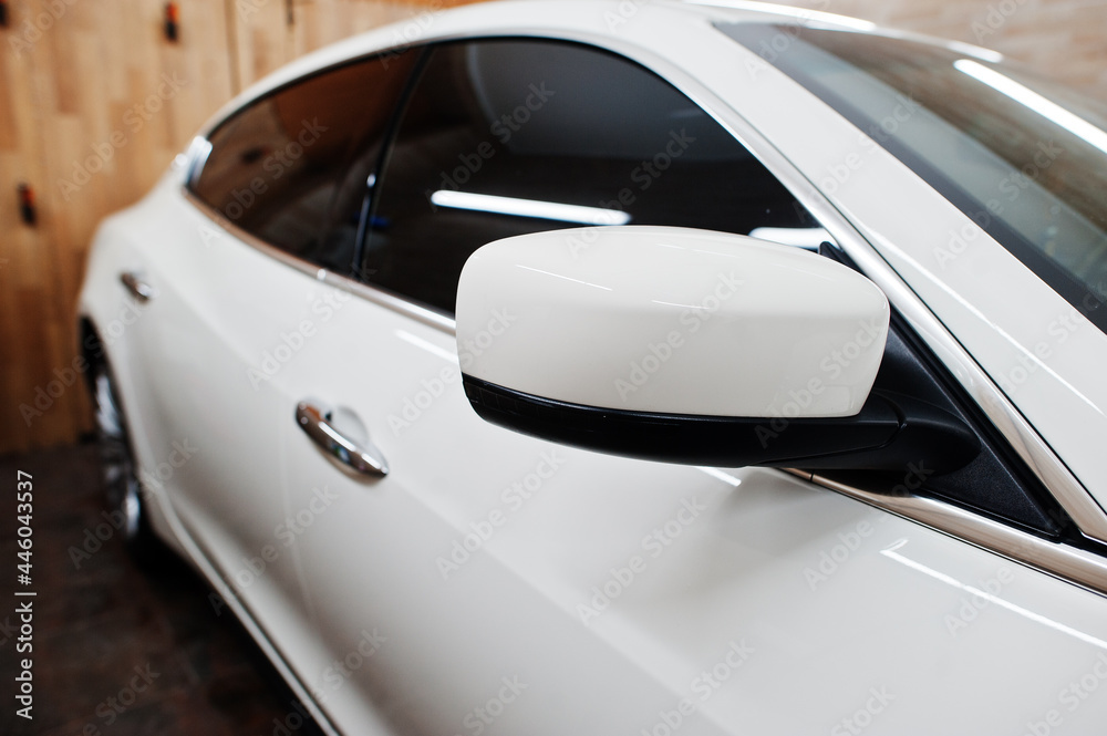 Mirror of white new luxury sport car in detailing garage.