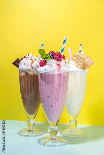 Summer refreshing drinks  milkshakes  crazy shakes with ice cream  berries  vanilla  chocolate. On a bright blue yellow background